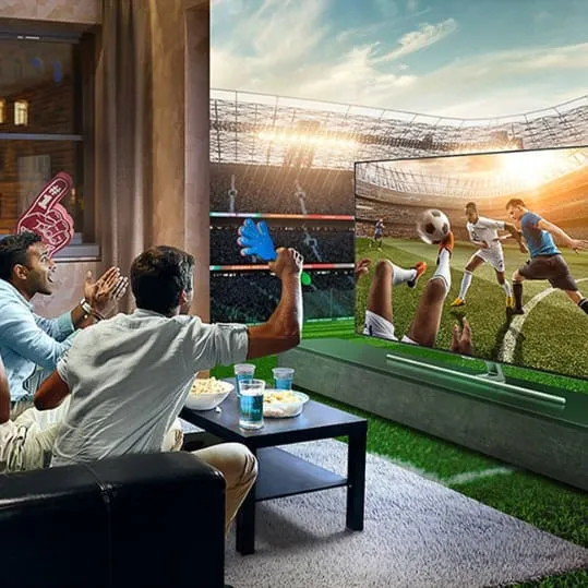 Friends cheering a live football match on a big-screen TV
